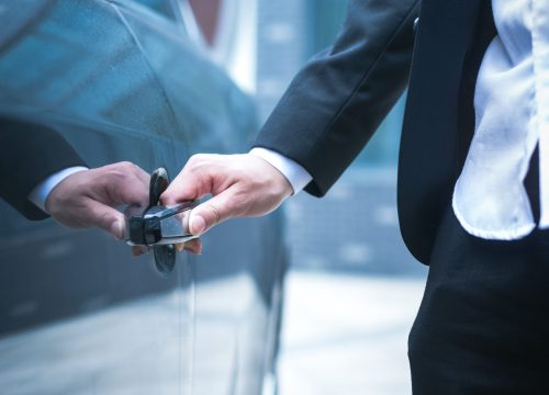 Hand of businessman opening door of car